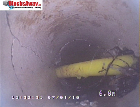 Gas pipe installed through foul drain causing recurring blockages